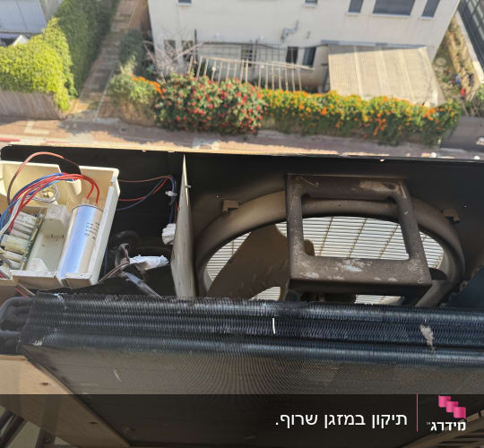 יחידת מזגן חיצונית עם מאוורר וחוטי חשמל